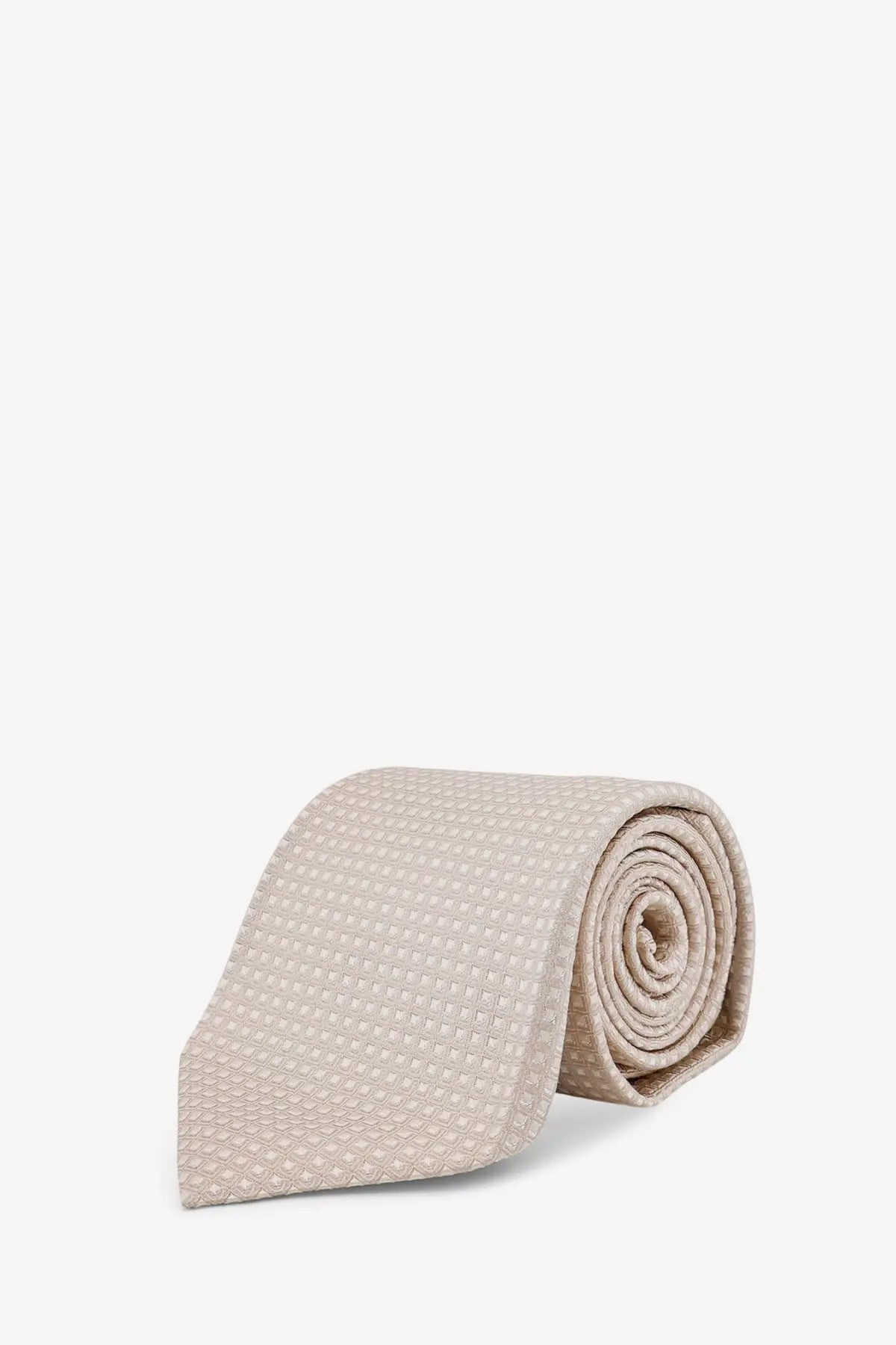 A neatly rolled tom ford men’s silk tie in beige with a subtle textured pattern