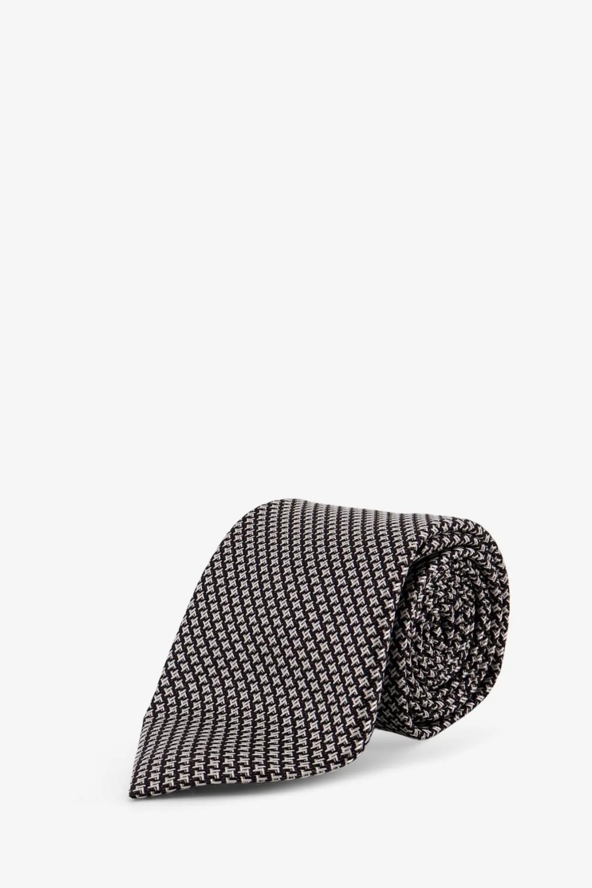 A neatly rolled black and white houndstooth patterned tom ford men’s silk tie