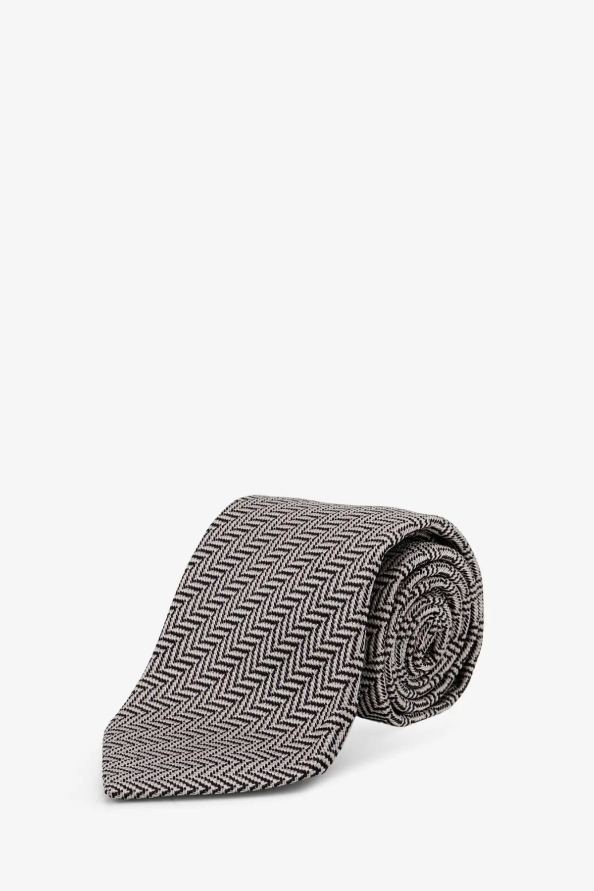 Tom Ford men’s silk tie in silver with a gray and black herringbone pattern neatly rolled