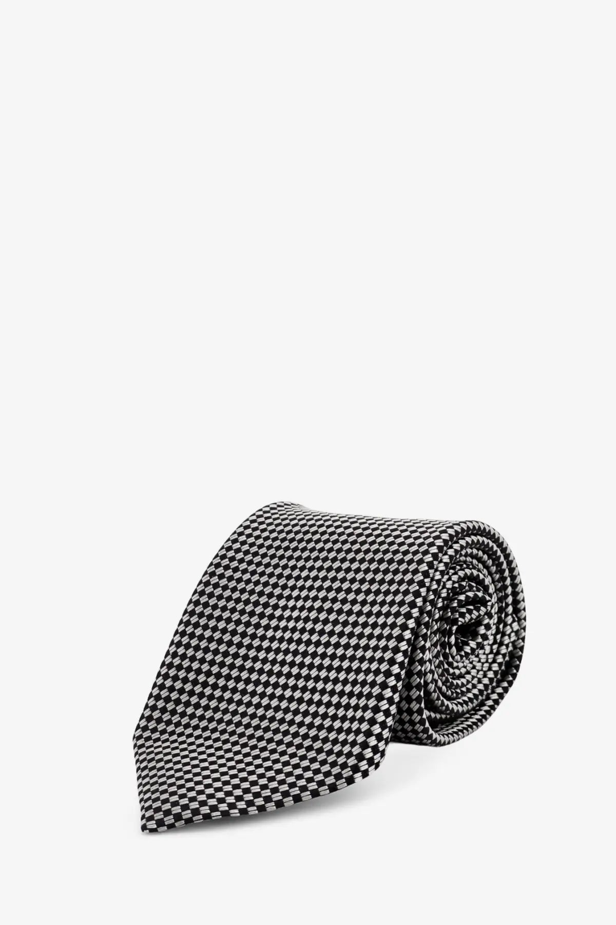 A sleek black and white houndstooth patterned Tom Ford men’s silk tie rolled neatly for display
