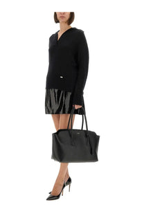 Black leather tote bag with structured shape and top handles shown alongside tom ford women’s cashmere and silk polo shirt