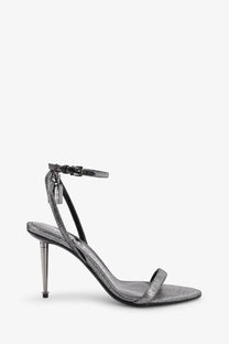 Tom Ford women’s laminated heeled sandals in silver with glittery ankle strap, slender metallic heel, and black leather accents