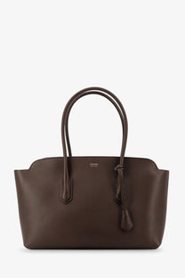 A sleek dark brown leather tote bag with curved handles and a subtle tom ford emblem on the front