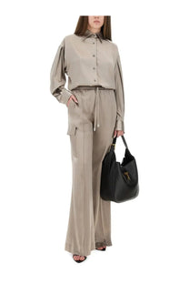 Black leather tote bag with gold tone hardware complementing tom ford women’s beige pj cargo pants