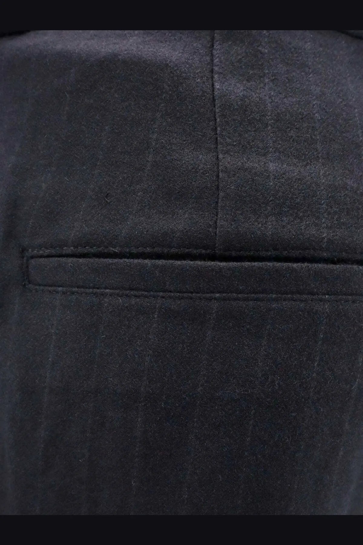 Dark charcoal pinstripe wool trousers with subtle textured weave and tailored seams for a sleek fit