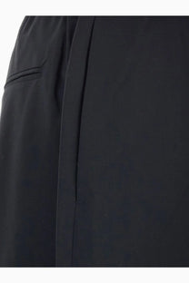 Black tailored Tonywack men’s wool blend trousers with sleek minimalist design and subtle pleating along side seam