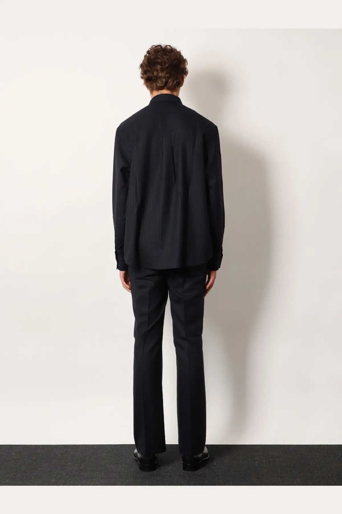 Black tailored wool blend suit with structured jacket and matching trousers paired with tonywack unisex blue striped shirt