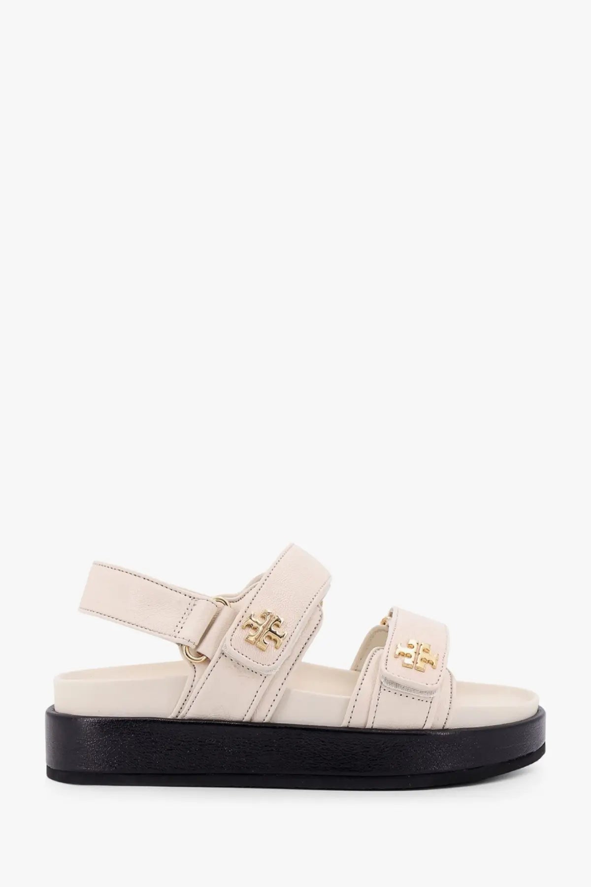 Cream-colored Tory Burch women’s Kira low leather platform sandal with black sole and gold-tone logo hardware