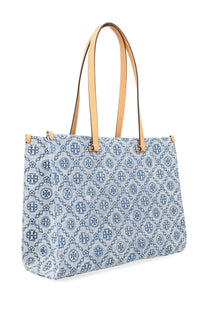 Light blue denim Tory Burch women’s monogram shopper bag with navy logo pattern and tan leather handles