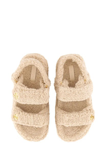 Tory Burch women’s beige fuzzy shearling sandals with gold-tone logo accents in Sandalo Kira style