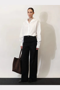 White oversized collar shirt with long sleeves and minimalist design paired with toteme women’s black denim jeans black