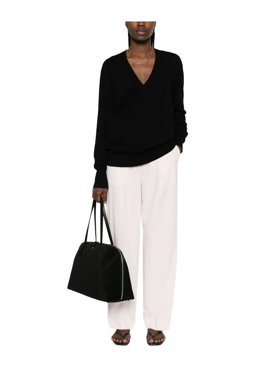 Black structured tote bag with subtle zipper detail and slender handles complementing toteme women’s cashmere sweater