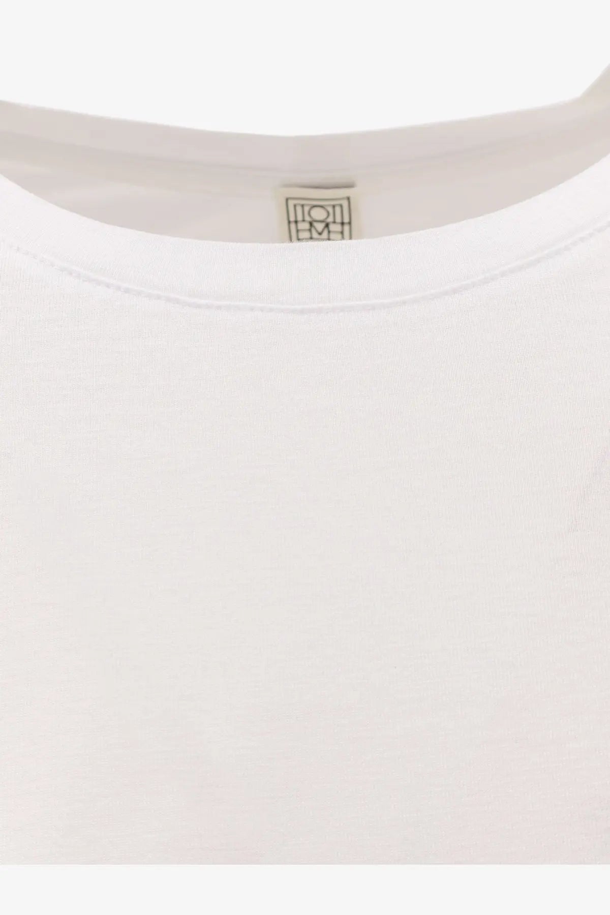 White cotton and lyocell long sleeve t-shirt by Toteme with minimalist logo tag at the neckline