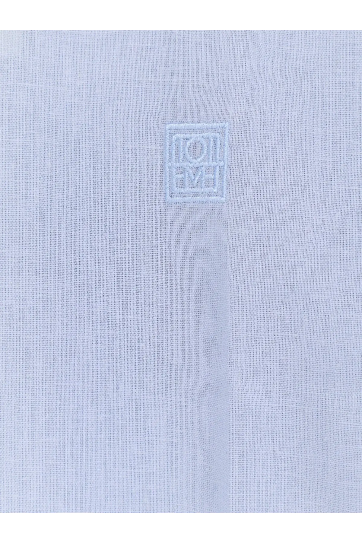 Light blue cotton and linen oversized summer shirt for women by Toteme with subtle embroidered logo on the chest