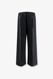 Back view of toteme women’s black linen and lyocell blend wide-leg trousers with elastic waistband and rear pockets