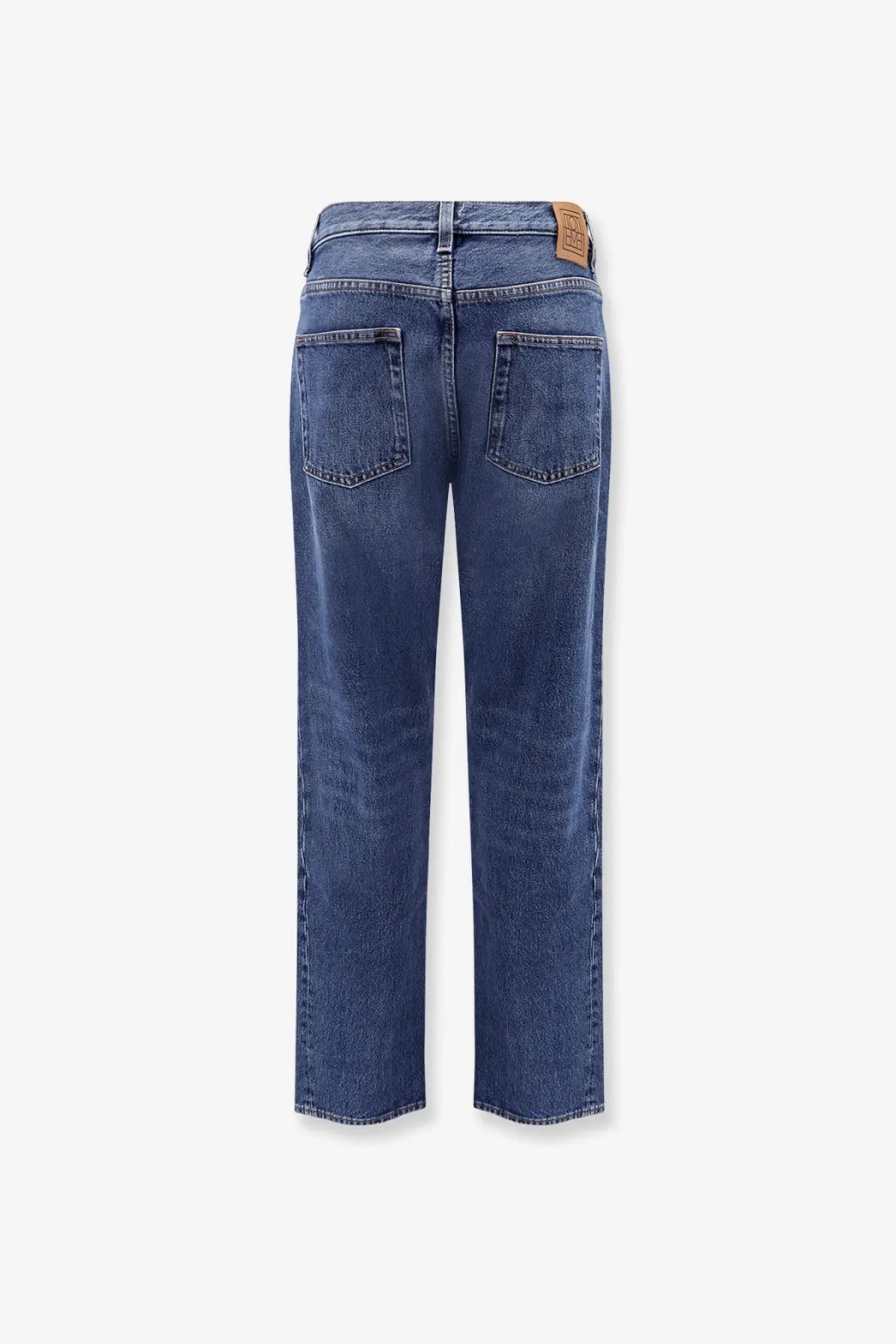 Blue denim jeans with a straight-leg cut and brown leather brand patch at waistband by Toteme women
