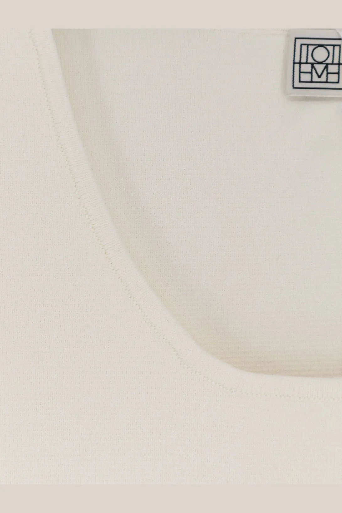 Toteme women’s white viscose blend tank top with a minimalist black logo patch on the upper right side