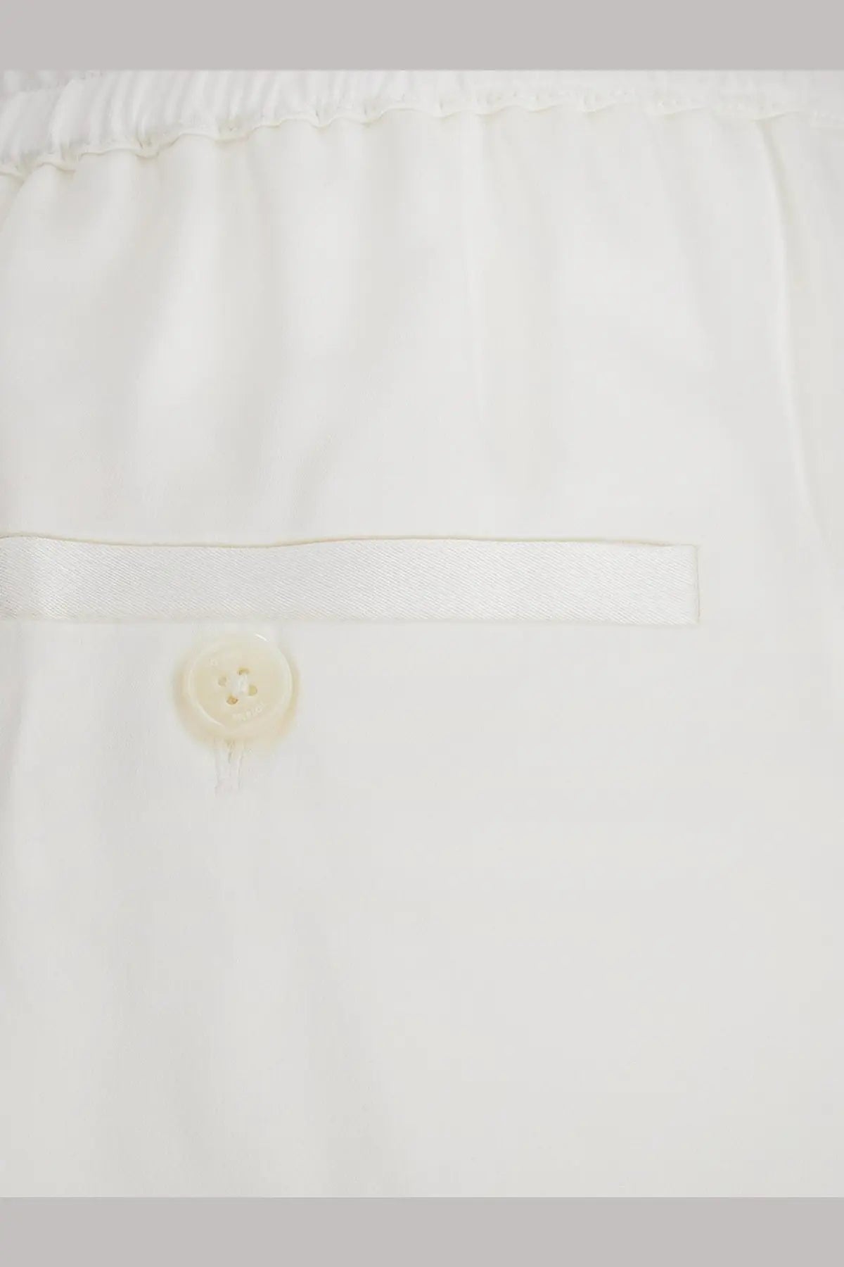 Toteme women’s white viscose trousers with subtle pleated waistband and single button closure