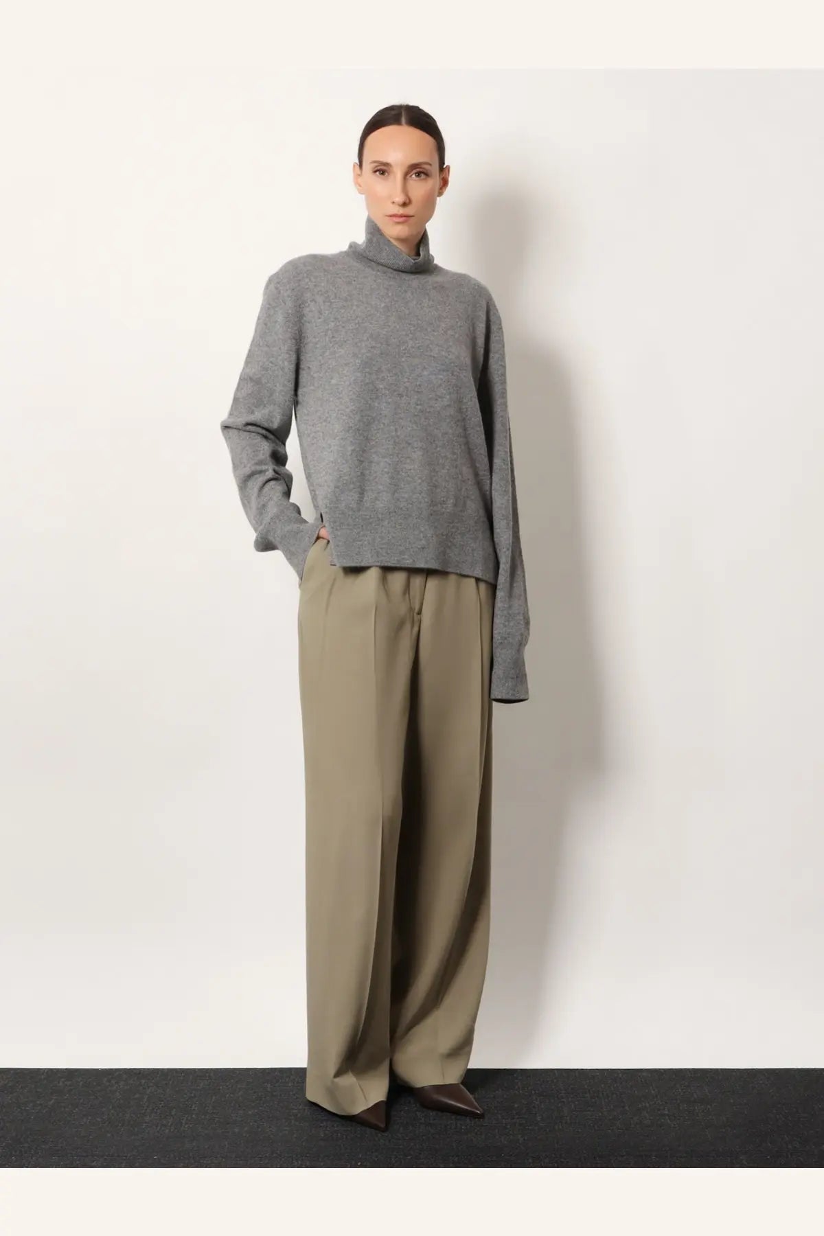 A soft heather gray turtleneck sweater with a relaxed fit and subtle texture paired with toteme beige viscose and wool trousers