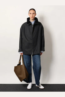 Black oversized coat with plush collar and front zipper paired with toteme women’s blue wide leg organic cotton jeans