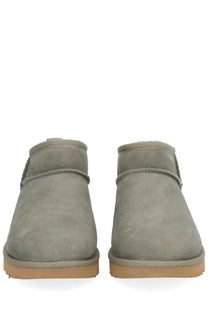 Ugg women’s classic ultra mini green gray suede booties with tan rubber sole and stitched detailing front view
