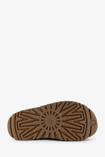 Ugg women’s brown rubber sandals featuring a brown rubber sole with starburst tread pattern and embossed ugg logo