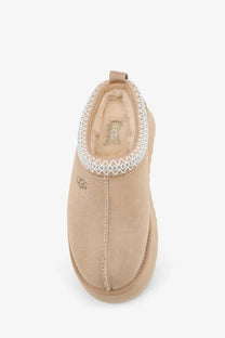 Beige ugg women’s tazz suede slip-on sandals with decorative white zigzag trim and soft suede exterior