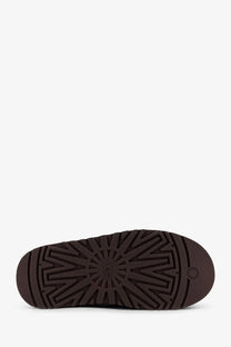 Dark brown rubber sole with radiating tread pattern and ugg logo on ugg women’s tazz suede slip beige slippers