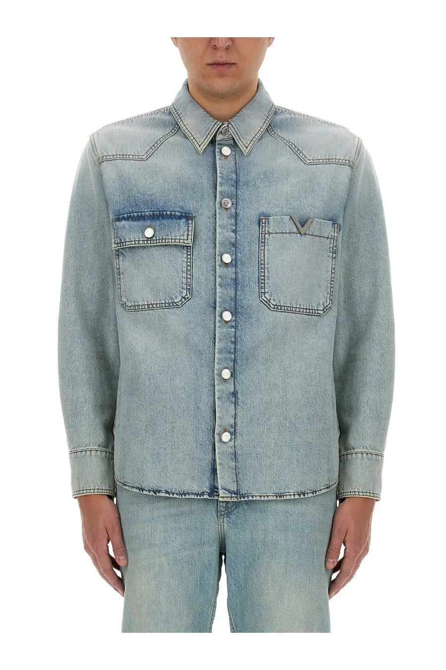 Valentino men’s light-wash denim button-up shirt in blue with two chest pockets and subtle v-shaped logo on right pocket