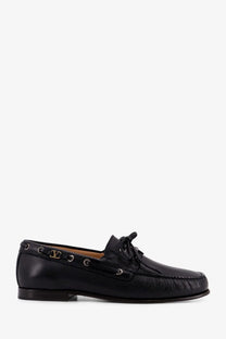 Black leather boat shoe with gold-tone Valentino logo plaque and eyelets in Valentino men’s leather loafers black