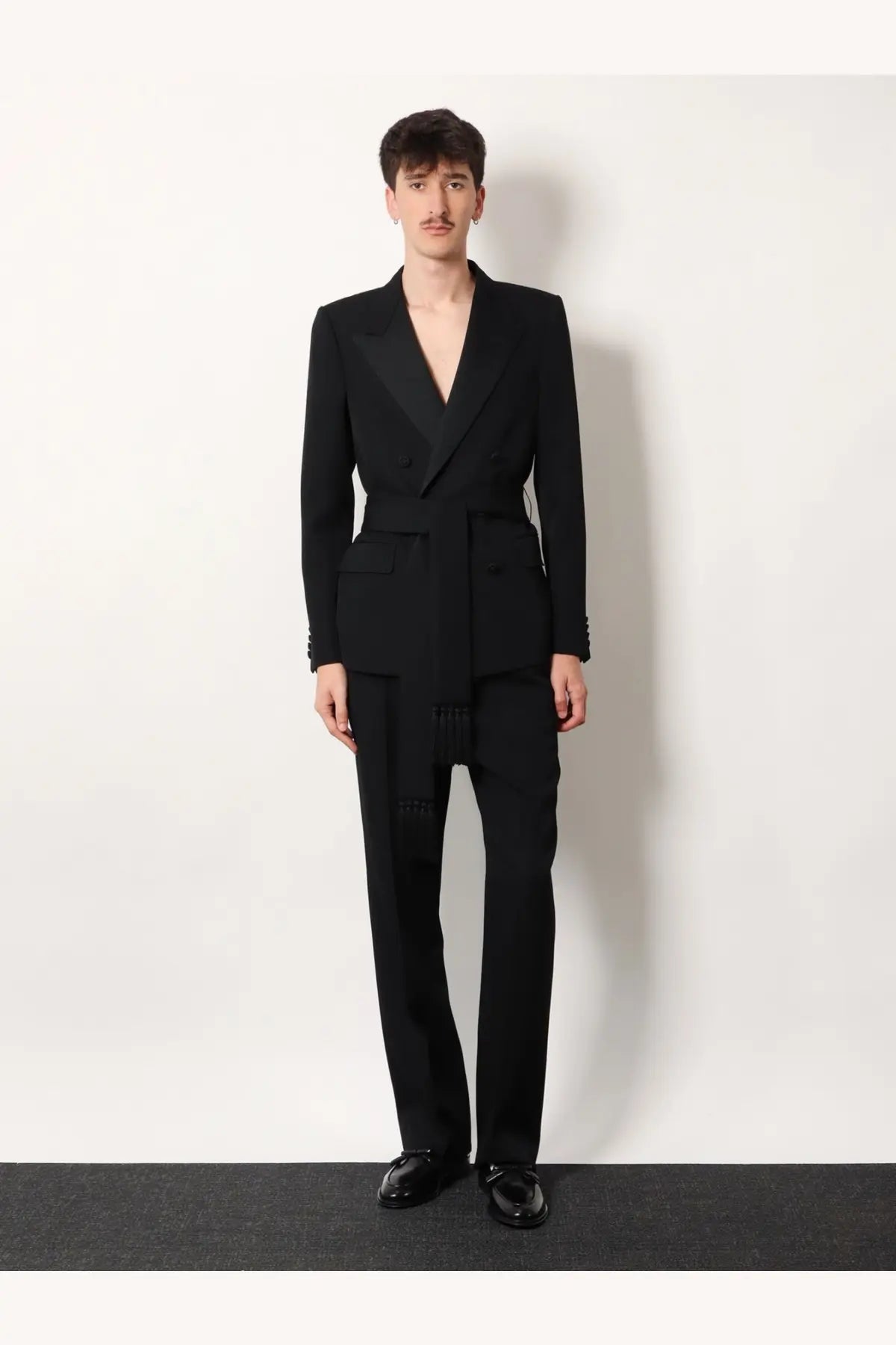 Black tailored suit with belted waist and notched lapels paired with valentino men’s virgin wool trousers black