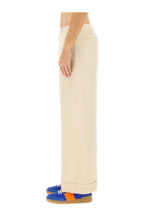 Valentino men’s beige wool pants with cream-colored wide-leg tailored cut and rolled cuffs