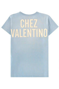 Light blue cotton valentino women’s shirt showing back with cream colored chez valentino print in block letters
