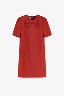 A vibrant red Valentino women’s short dress in wool and silk blend with a structured bodice and bow neckline