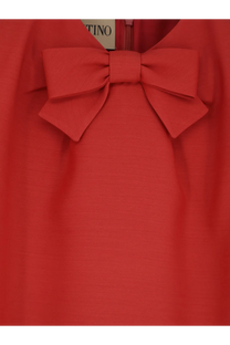 A vibrant red valentino women’s wool and silk blend short dress with a prominent bow at the neckline