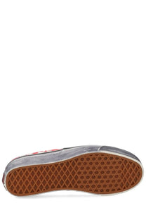 Gray vans unisex slip-on sneaker with red and white checkered side panel and brown rubber sole