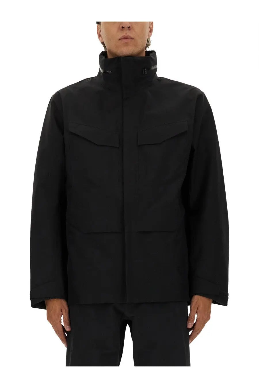 Veilance men’s black tactical jacket with high collar and four large flap pockets in a sleek modern design