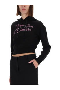 Versace Jeans Couture women’s black cropped hoodie with pink sequined logo lettering on the chest