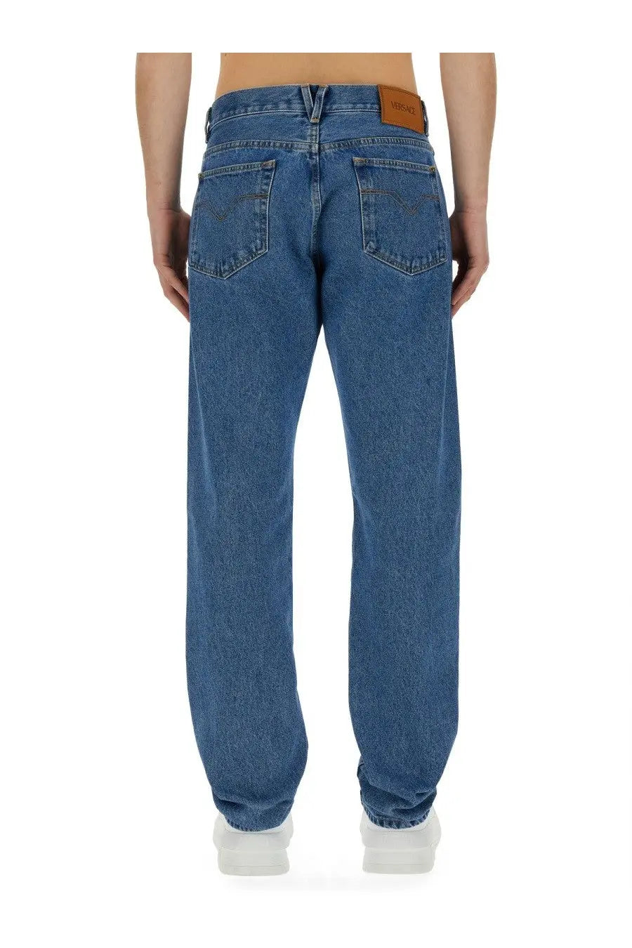 Blue denim versace men’s regular fit jeans with a brown leather brand patch at the waistband back view