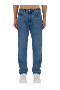Versace men’s regular fit medium-wash blue denim jeans with classic five-pocket design and worn-in look