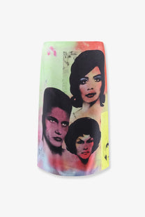 A cylindrical ceramic vase with a vibrant pop art print of three stylized faces in black and pink on pastel green