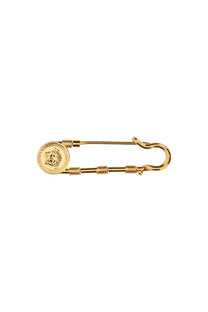 Versace women’s gold safety pin featuring a medusa head medallion and twisted wire detailing