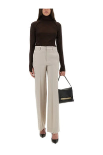 Black leather handbag with gold-tone chain detailing paired with victoria beckham women’s beige classic straight leg pants