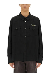 Visvim men’s black button-up shirt with white embroidery on left chest and two front pockets with classic collar design