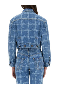Back view of vivienne westwood womens cropped blue denim jacket with repeating white westwood script print on sleeves and back