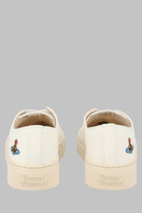 Back view of cream-colored vivienne westwood women sneaker low top plimsoll slip-on with embroidered logo heel detail