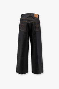 Back side of walk in Paris men’s baggy blue denim jeans in dark indigo with embroidered w logos and leather patch