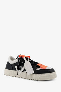 Off-White men’s court low top leather sneaker in black and off-white with orange tag accents visible from the front side