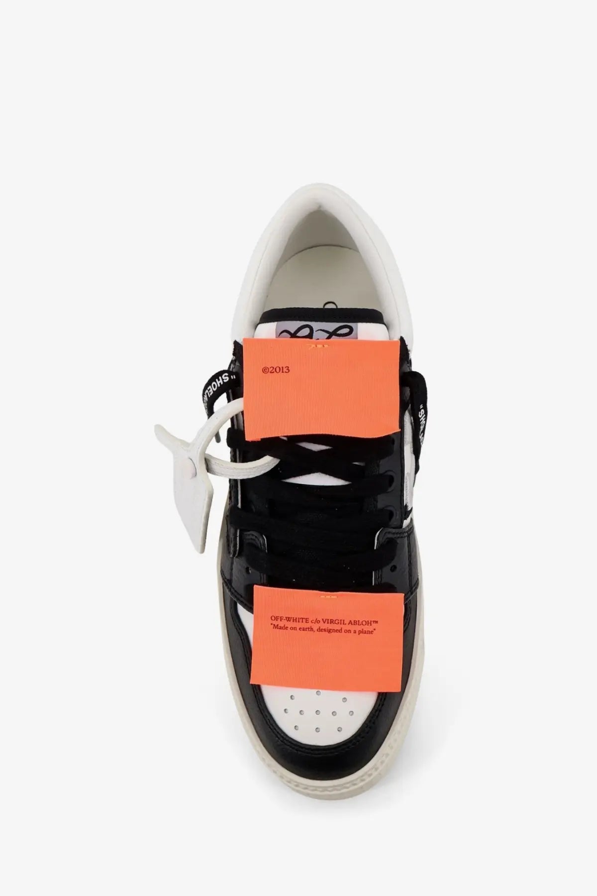 Off white men’s court low top leather sneakers in black and off white with orange tags showing side view