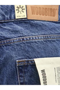Blue denim jeans with a tan woodbird leather patch and white size label w32 l32 front view for men